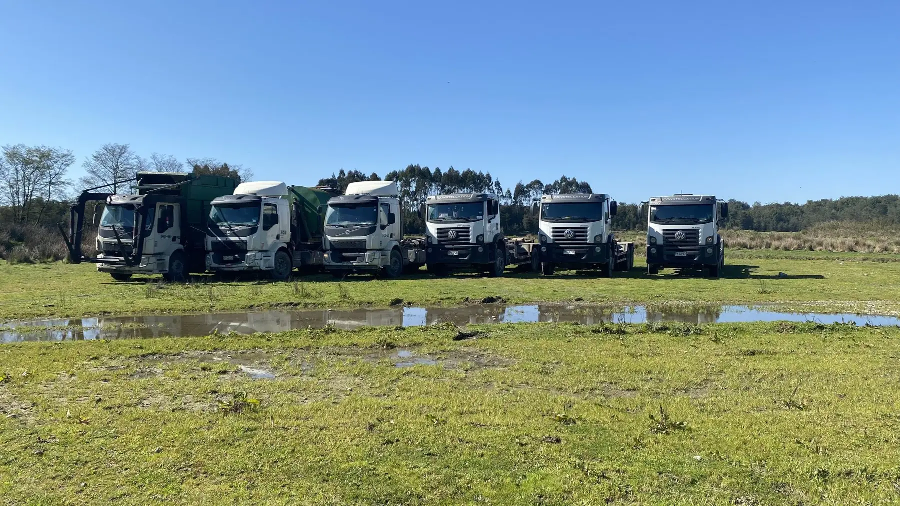 Camiones de la flota de retiro de residuos estacionados en terreno